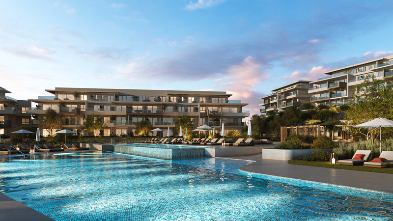 Altos del Chaparral – Mijas Costa - luxury outdoor swimming pool with sun loungers and modern residential buildings at dusk