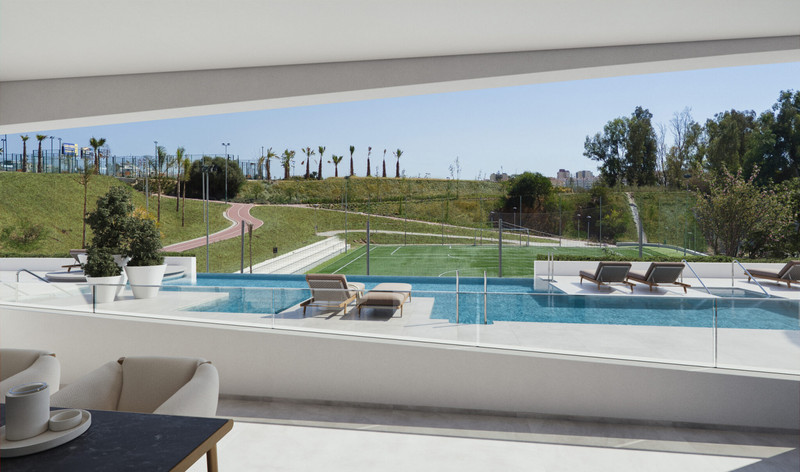 7 Olas – Fuengirola - luksuriøs infinity-pool terrasse med solstoler og utsikt over grønn idrettsbane og velstelte omgivelser