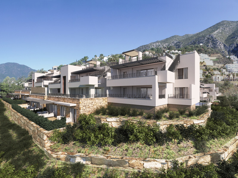Almazara Forest + Gardens – Istán - modern white terraced residential complex with mountain backdrop and landscaped stone terraces