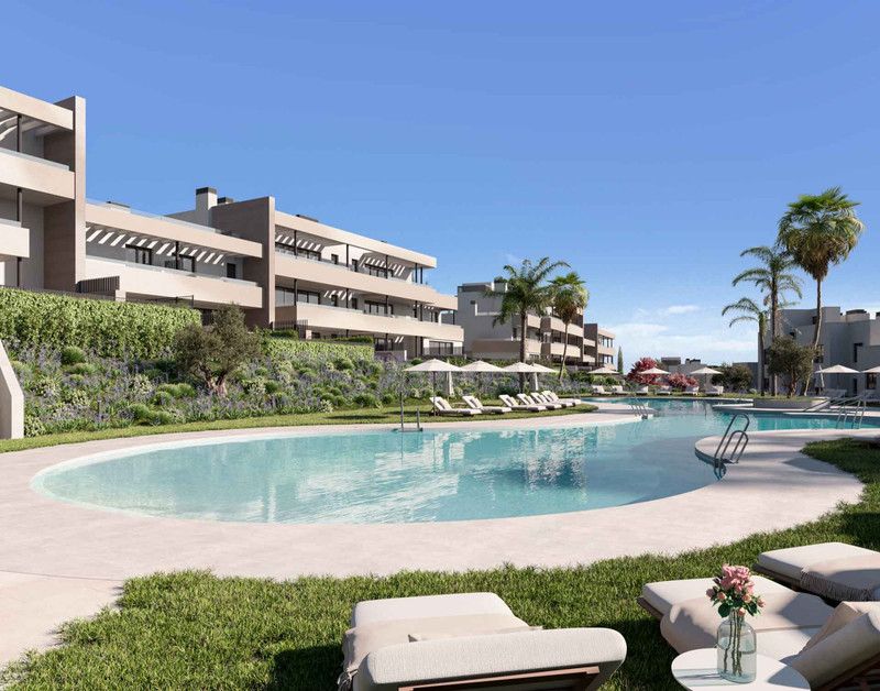 Bliss Homes – Casares - luksuriøst fellesbasseng og anlagte hager med moderne leilighetskompleks i bakgrunnen