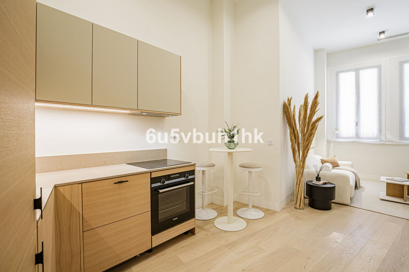 Calle Jinetes – Málaga Centro - open-plan kitchen and living area with light wood cabinetry and high bar table