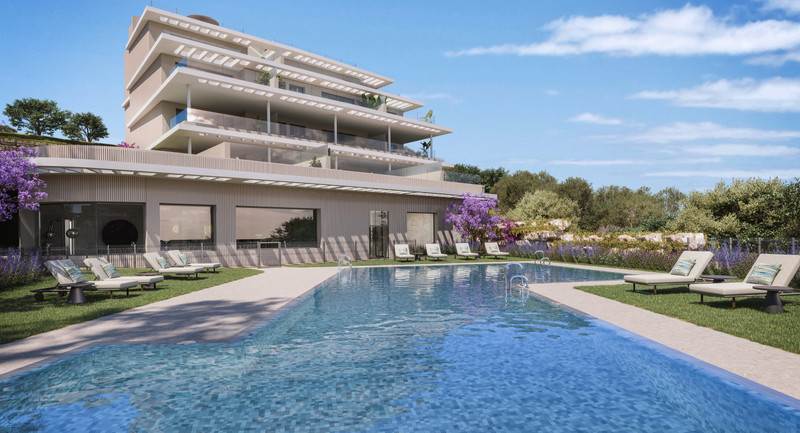Capri – Fase 3 – Estepona - modern luxury apartment building with communal pool, sun loungers and landscaped gardens