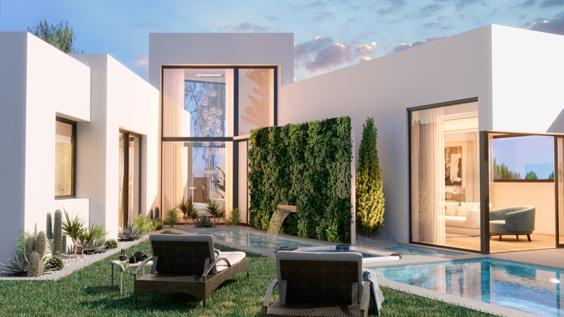 Carib Playa – Marbella - moderne hvit villaeksterior med privat basseng, solstoler, vertikal urtehage og opplyst interiør i skumringen