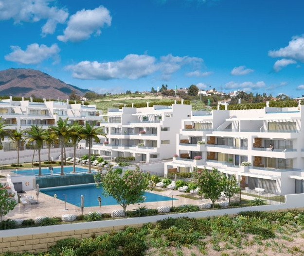 Costafiore Gardens – Fase 1 – Estepona - luftfoto av hvit moderne boligkompleks med utendørs bassenger, palmetrær og fjell i bakgrunnen