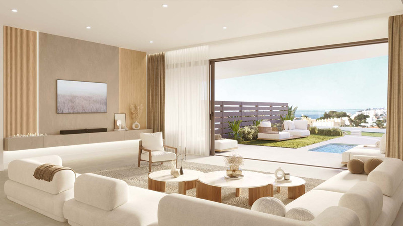 Korall – Fuengirola - lys åpen stue med hvite sofaer, trekaffebord og skyvedører mot poolterrasse med havutsikt