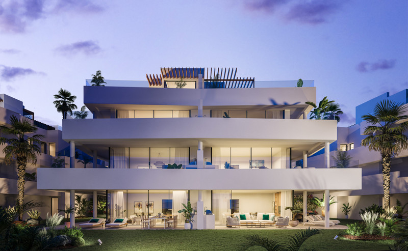 Mirador de Estepona Hills – Estepona - belyst moderne leilighetsbygning i skumringen med velstelte hager og brede terrasser