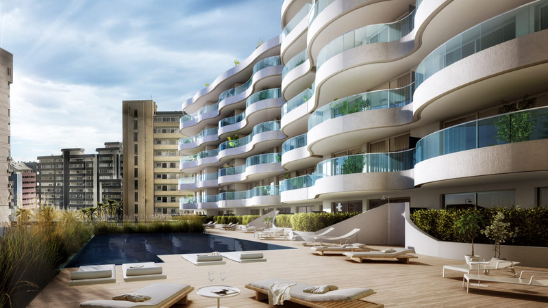 Nova Marina – Fuengirola - buet hvit fasade med glassbalkoner rundt et takteras med solsenger og basseng