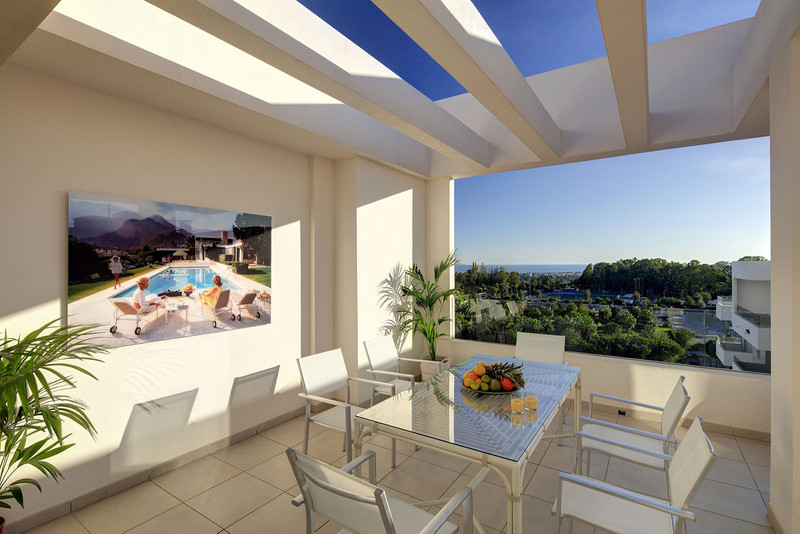 Residencial Albatros Xiv – Marbella - overdekket terrasse med glassbord, hvite stoler, havutsikt og frodig hage