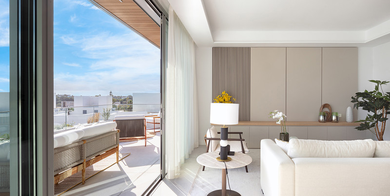 Santa Clara Homes – Marbella - lyst stuerom med gulv-til-tak skyvedører som åpner mot solrik terrasse med tagutsikt