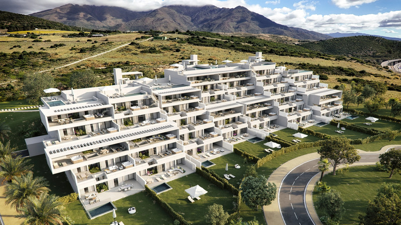 The Place Alcazaba – Casares - luftfoto av hvit modernistisk boligkompleks med terrasser, bassenger og fjell i bakgrunnen