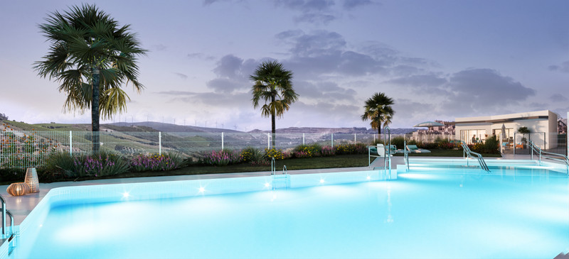 Alonia – Manilva - illuminated outdoor swimming pool at dusk with palm trees and rolling hillside views
