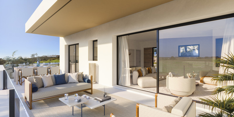 Attire Estepona – Estepona - solrik terrasse med kremfargede utemøbler og gulv-til-tak skyvedører i glass