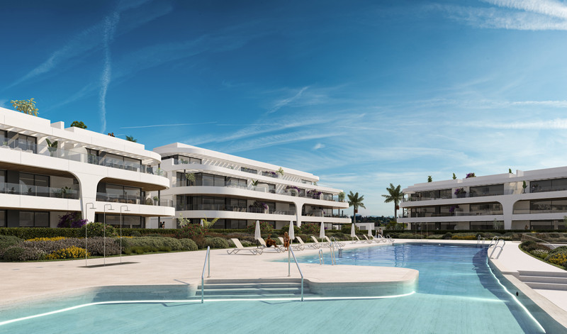 Naya Residences – Atalaya - luxury white apartment complex with communal infinity pool, sun loungers and landscaped gardens