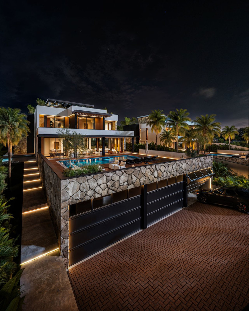 Manzanilla 12 – New Golden Mile - luxury two-storey villa exterior at night with illuminated pool terrace and stone retaining walls