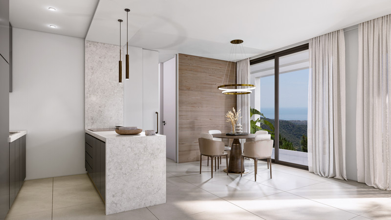 Villa Evania – Benahavís - open-plan kitchen and dining area with marble island, round table, and panoramic sea views through floor-to-ceiling glass doors
