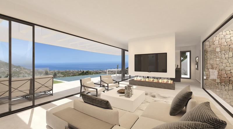 Villa La Ermita – Mijas - bright open-plan living room with floor-to-ceiling glass doors, fireplace, and panoramic sea views