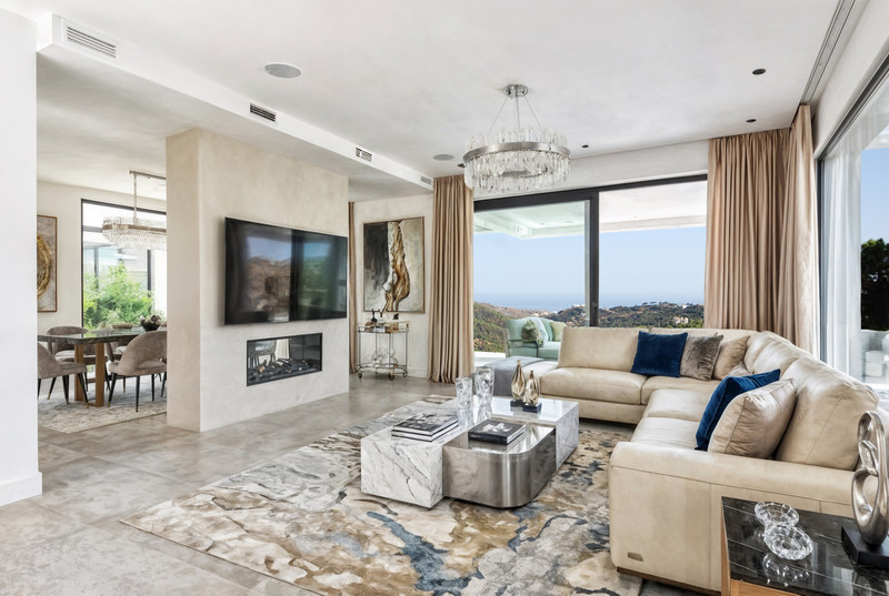 Zoe Luxe – Benahavís - luxury living room with marble coffee table, sectional sofa, fireplace, and panoramic sea views
